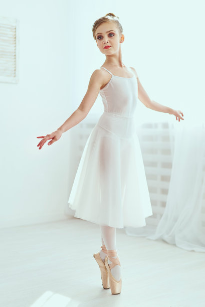 美丽的芭蕾舞女演员在一个白色的充满光线的工作室里摆姿势跳舞。这张照片极大地反映了古典芭蕾艺术无与伦比的美。图片下载