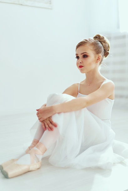 美丽的芭蕾舞女演员在一个白色的充满光线的工作室里摆姿势跳舞。这张照片极大地反映了古典芭蕾艺术无与伦比的美。图片下载