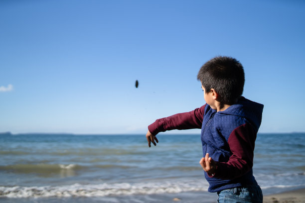 孩子们往海里扔石头。图片下载