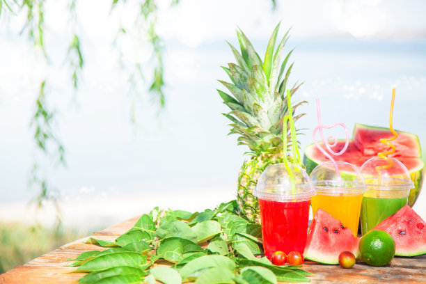 新鲜健康的果汁，水果，菠萝，西瓜在大海的背景。夏日、休息、健康的生活方式复制空间图片下载
