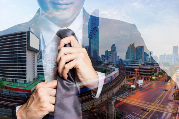 双重曝光的年轻快乐的商人与黑色西装调整他的领带曼谷城市景观和BTS Skytrain概念开始新的生活和新的工作在城市背景。图片下载
