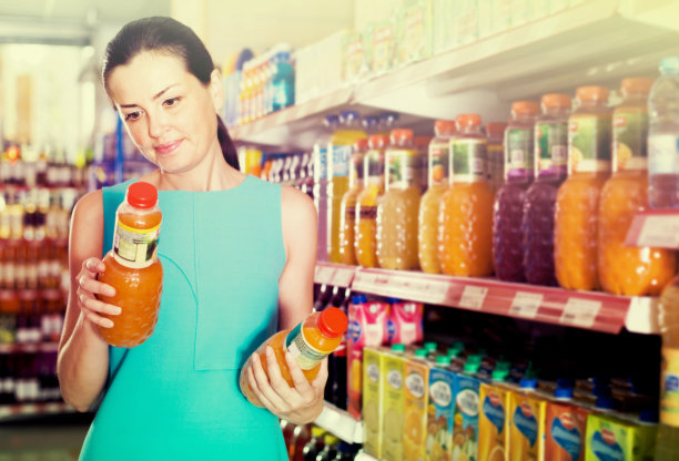 女顾客在超市挑选果汁图片下载