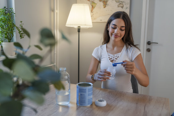母亲正在用奶瓶制作婴儿配方奶粉，给刚出生的婴儿喂奶图片下载