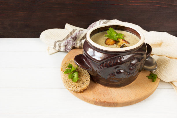 锅里的蘑菇汤和木板上的烤面包图片下载