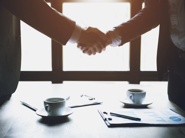 关闭了。两个商人在咖啡馆里握手。图片下载