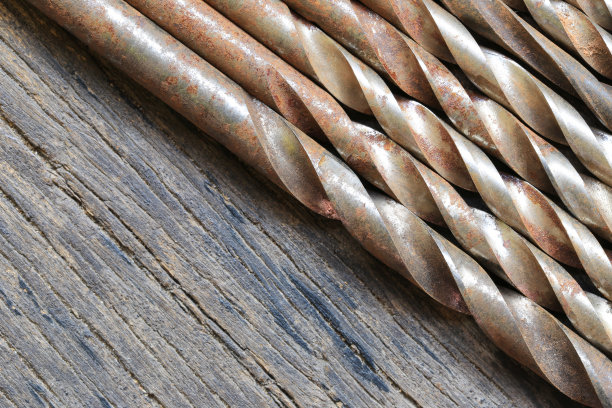 旧钻杆放在棕色的木地板上。图片下载