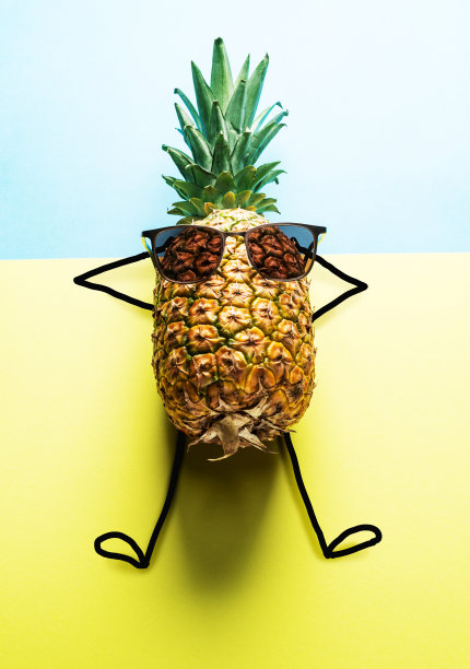 蓝黄相间的背景上戴着太阳眼镜的菠萝男。图片下载