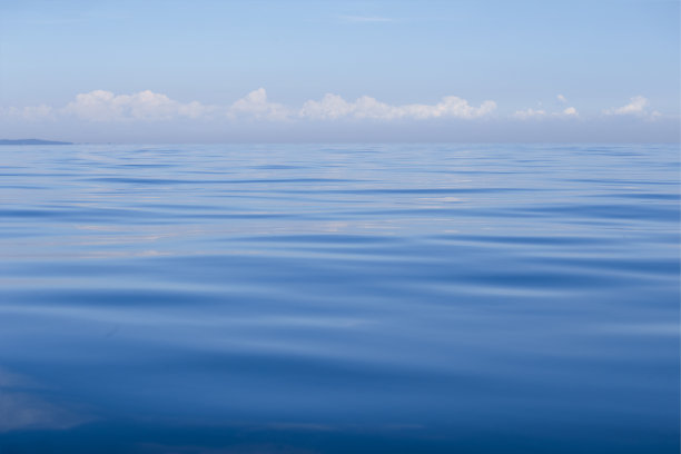 蓝色的水面和天空与云图片下载