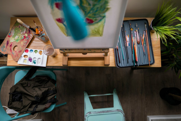 木桌上有油漆刷、油漆管和抹布图片下载