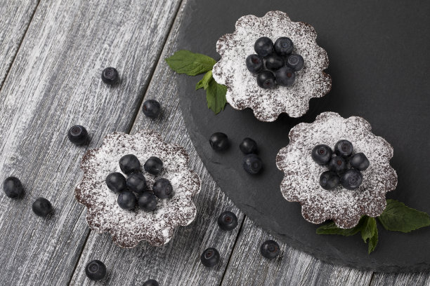 桌上放着蓝莓蛋糕和糖粉。图片下载