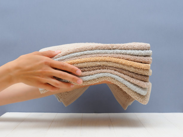 一个女人拿着一叠毛巾。酒店、洗衣房、水疗中心的服务理念。特写镜头图片下载
