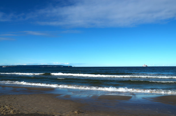 深蓝色的大海与波浪和渡船通过鲁根岛在地平线上。图片下载