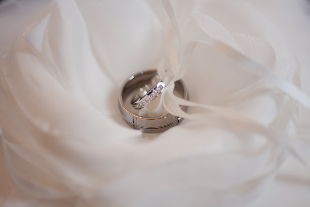 白色的花和枕头上戴着结婚戒指图片下载
