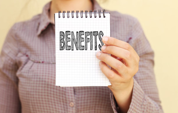 拿着一本写着福利的笔记本的女商人图片下载