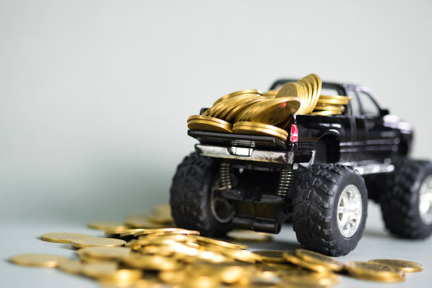 微型汽车皮卡卡车与硬币堆叠在灰色背景与拷贝空间，银行储蓄资金和商业金融的概念。图片下载