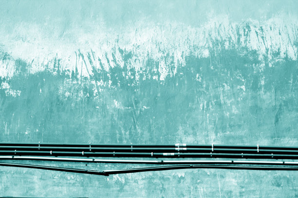 青色的电缆挂在破旧的水泥墙上。图片下载