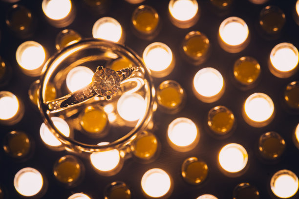 近距离的钻石婚戒在黄金背景与复制空间和选择性焦点图片下载