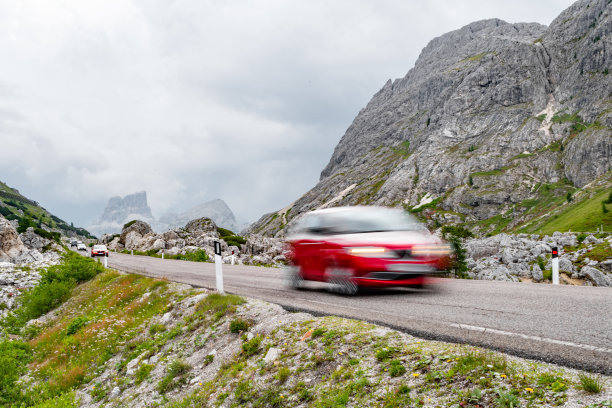 一辆模糊的红色汽车在山路上超速行驶图片下载