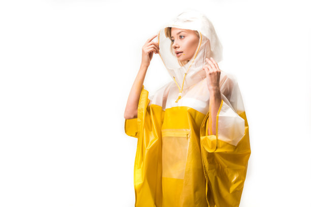 美丽的女人穿着雨衣，拿着兜帽，看着远处孤立的白色图片下载