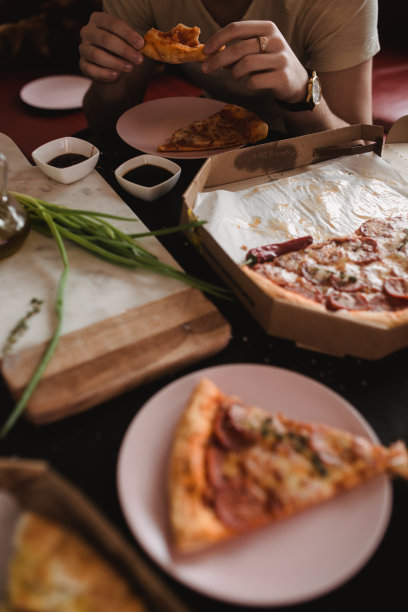 木桌上的聚会用披萨和亮色餐盘。深色乡村风食物照片。俯视图像图片下载