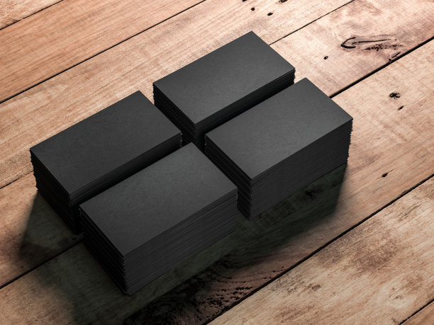 木桌背景上有四叠黑色名片图片下载