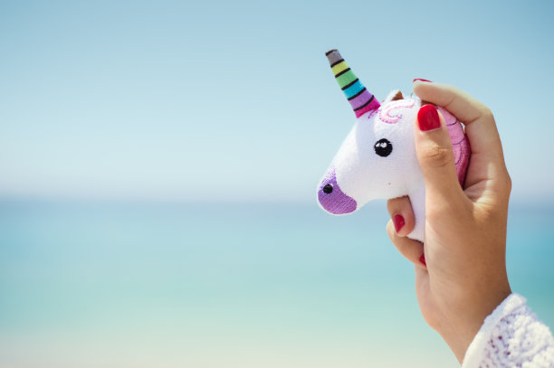 牵手粉色新潮独角兽在蓝天的背景。空的空间。图片下载