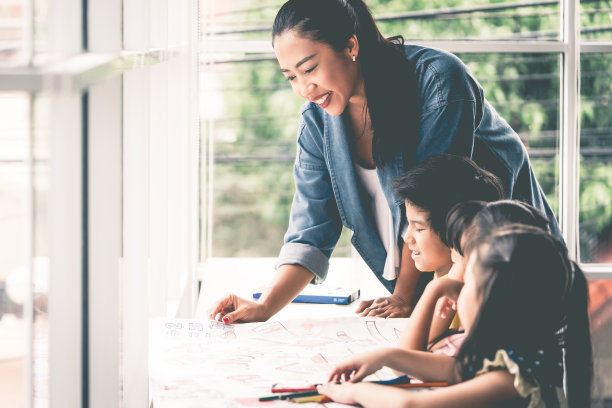 幼儿园美术教室里，老师和孩子们在画画图片下载