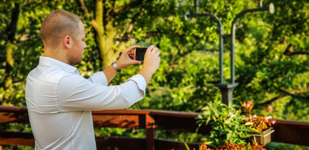 英俊的男人-站立的男人-商人-商人用电话拍照片图片下载