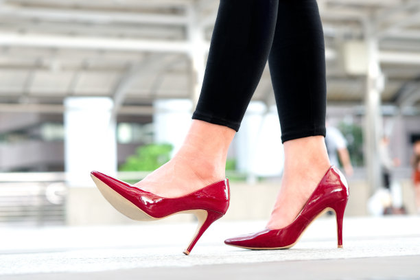 女人的美腿穿上红色的高跟鞋走在街上。美丽与健康理念图片下载