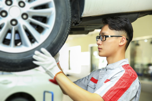 亚洲汽车修理工人检查轮胎图片下载