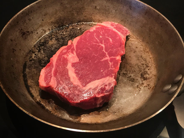 肋眼牛排在铸铁锅中烹饪图片下载