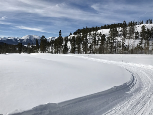 在一个阳光明媚的日子里，在科罗拉多的一个越野步道和积雪覆盖的山脉图片下载