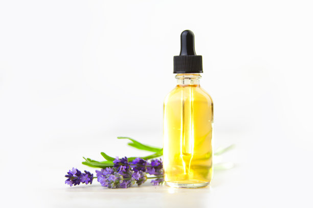 薰衣草精油在美丽的瓶子在白色的背景图片下载