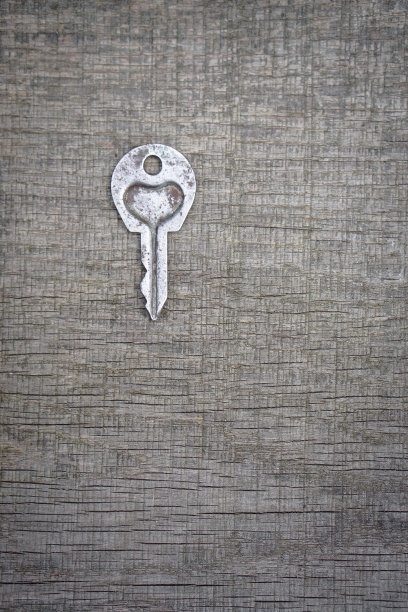 情人节或婚礼的浪漫背景。一把旧钥匙，在一块旧木板上刻着一颗心。设计素材照片图片下载