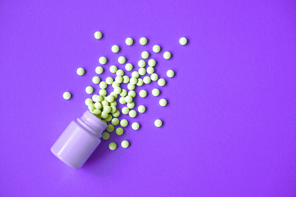 各种药物药丸，片剂，胶囊和瓶子在紫色的背景。毒品和各种麻醉药品。为文本复制空间。设计素材照片图片下载