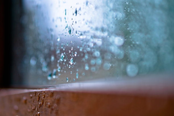 窗外多雨，秋天的天气。模糊的背景上的玻璃上的水滴。浪漫的肮脏的话题。设计素材照片图片下载