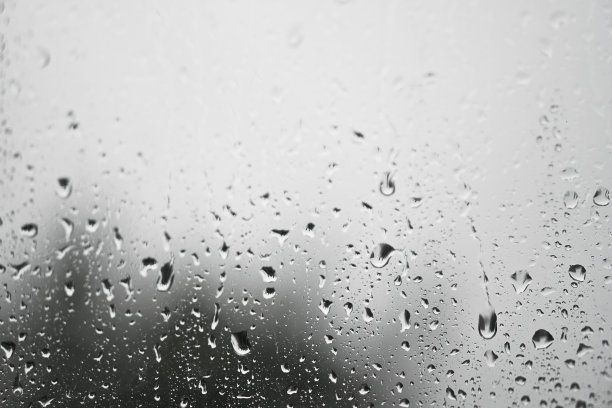 窗外多雨，秋天的天气。模糊的背景上的玻璃上的水滴。浪漫的肮脏的话题。设计素材照片图片下载