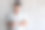 年轻帅气的男子戴着无线耳机和t恤，用触摸屏检查智能手表，站在灰色纹理的墙壁与复印空间图片下载