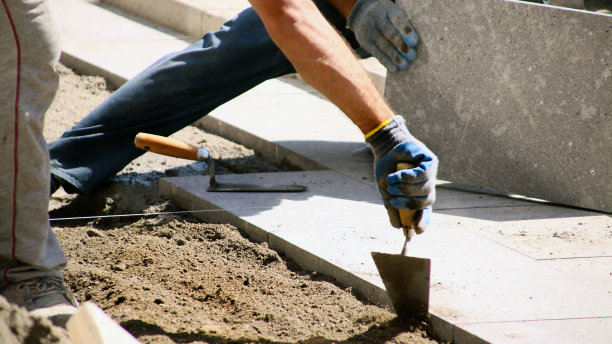 一个工人在人行道上做包裹。图片下载