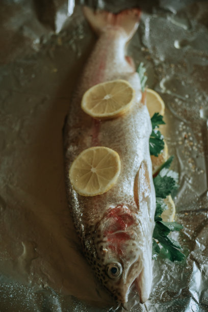 新鲜的鱼与香草和柠檬箔准备烘烤图片下载