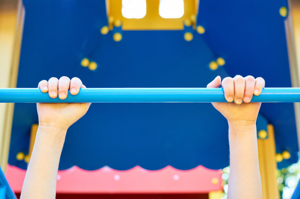 运动单杠为儿童在公共操场上使用，用儿童的手握图片下载