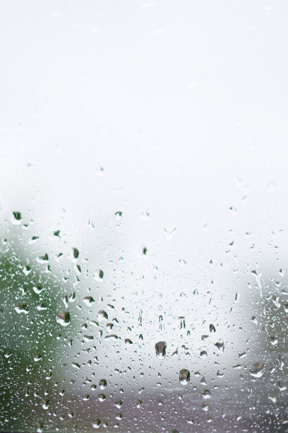 窗外多雨，秋天的天气。模糊的背景上的玻璃上的水滴。浪漫的肮脏的话题。设计素材照片图片下载