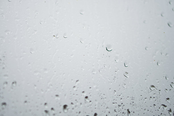 窗外多雨，秋天的天气。模糊的背景上的玻璃上的水滴。浪漫的肮脏的话题。设计素材照片图片下载