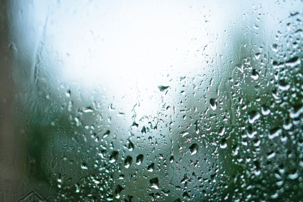 窗外多雨，秋天的天气。模糊的背景上的玻璃上的水滴。浪漫的肮脏的话题。设计素材照片图片下载