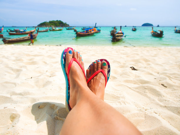 在海滩上晒黑了腿的女人。图片下载