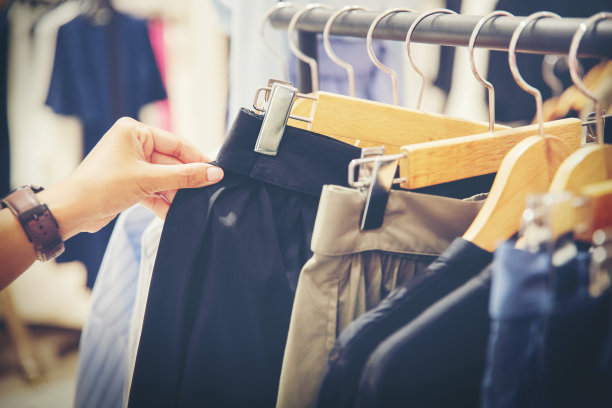 在服装店挑选裙子的顾客的手图片下载