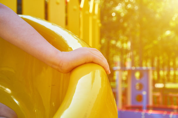 儿童游乐场在公园里，儿童的娱乐和娱乐用儿童的手，阳光的效果图片下载