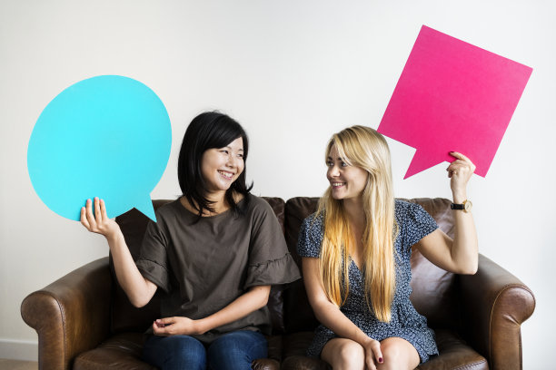 快乐的亚洲和白人女性朋友持有拷贝空间演讲泡泡图片下载