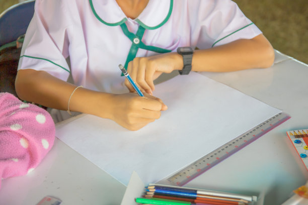 那个女孩坐在教室的桌子旁画画图片下载