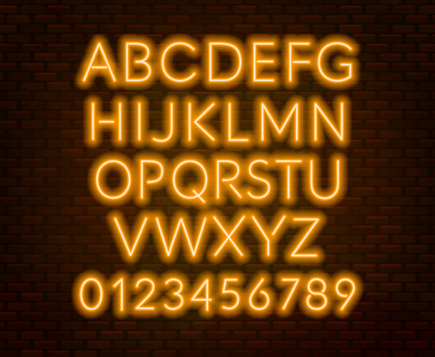 砖墙背景上的霓虹橙色字母。大写字母。图片下载
